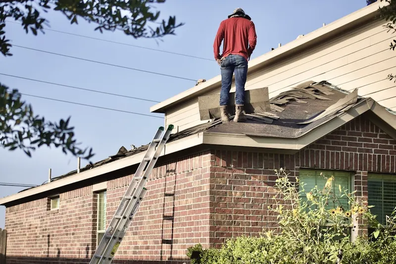 Professional roofer working on a residential roof in Holly View Forest-Highland Park